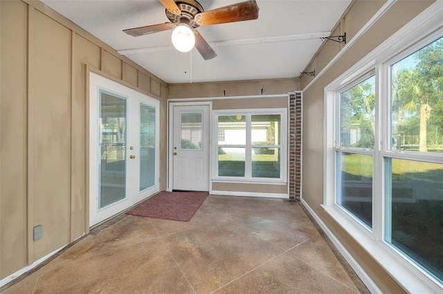 unfurnished sunroom featuring ceiling fan