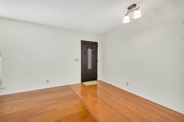 unfurnished room featuring wood-type flooring and a textured ceiling