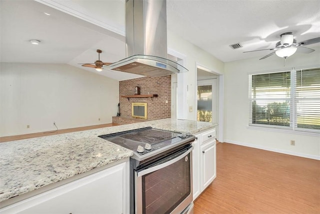 kitchen with white cabinetry, light stone countertops, electric stove, ceiling fan, and island exhaust hood