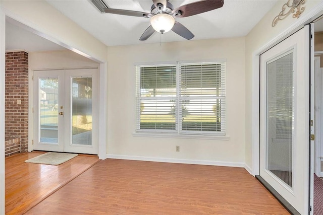 interior space featuring ceiling fan, light hardwood / wood-style flooring, brick wall, and french doors