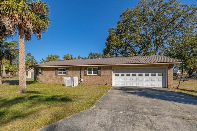 ranch-style house featuring a garage and a front lawn