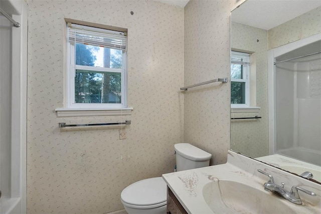 bathroom featuring toilet, a healthy amount of sunlight, and vanity