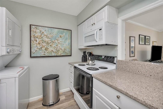 kitchen featuring white cabinetry, white appliances, stacked washing maching and dryer, and light wood-type flooring