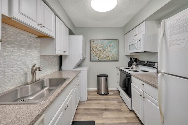 kitchen with sink, white appliances, light hardwood / wood-style floors, decorative backsplash, and white cabinets