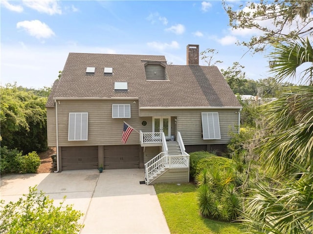 207 Military Rd, Saint Simons Island, GA 31522 - view of front facade with a garage, stairway, a chimney, concrete driveway, and a shingled roof
