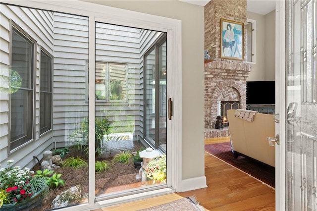 207 Military Rd, Saint Simons Island, GA 31522 - doorway to outside with wood finished floors and a brick fireplace