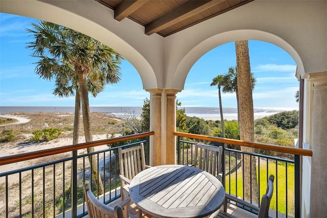 balcony featuring a view of the beach and a water view