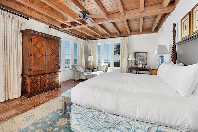 tiled bedroom with beamed ceiling, ceiling fan, and wood ceiling