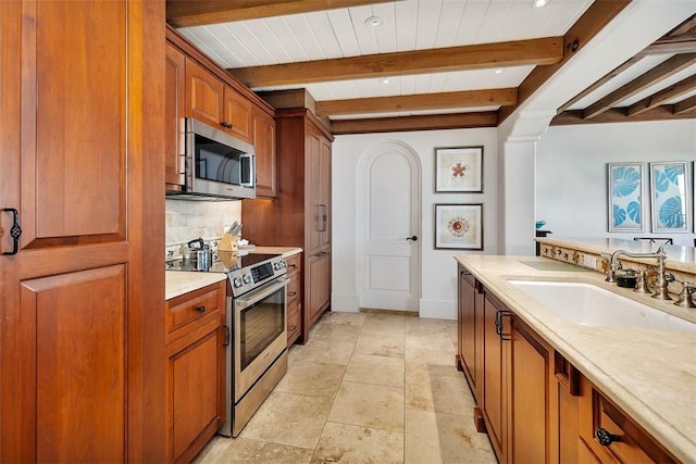 kitchen with beam ceiling, decorative backsplash, sink, and appliances with stainless steel finishes