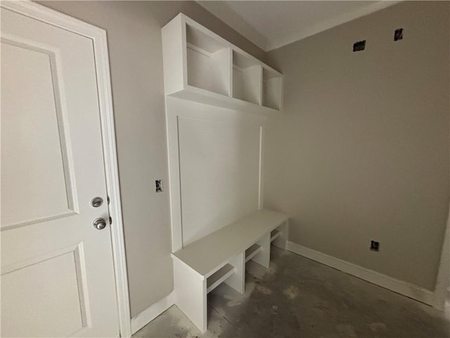 mudroom featuring baseboards and unfinished concrete flooring