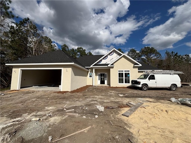 view of front of home with stucco siding and a garage