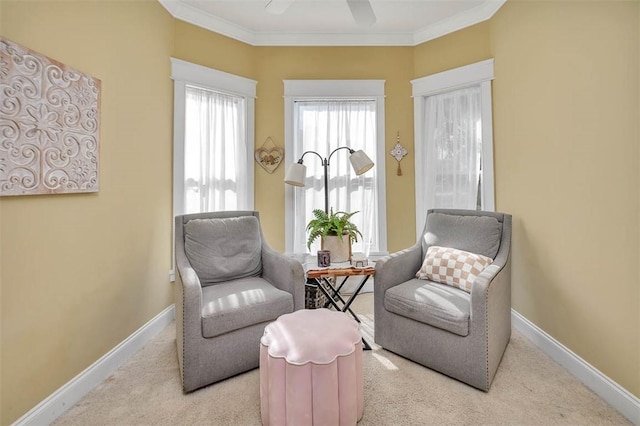 living area with ceiling fan, crown molding, and light colored carpet