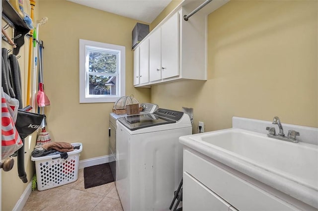 washroom featuring washer and clothes dryer, light tile patterned flooring, cabinets, and sink