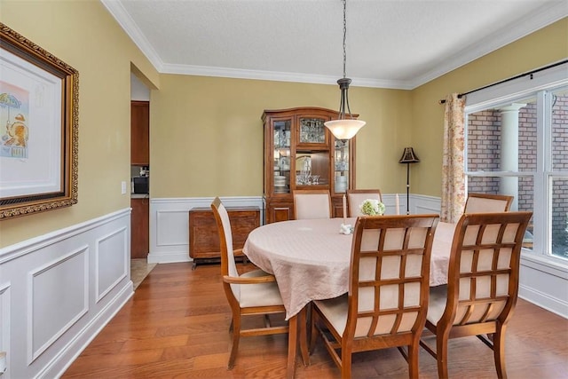 dining room with hardwood / wood-style flooring and ornamental molding