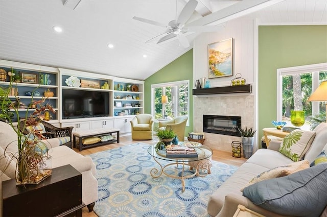 552 Old Plantation Rd, Jekyll Island, GA 31527 - living room featuring wood finished floors, lofted ceiling, healthy amount of natural light, a tiled fireplace, and a ceiling fan
