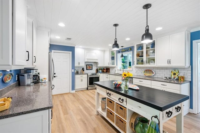 552 Old Plantation Rd, Jekyll Island, GA 31527 - kitchen with appliances with stainless steel finishes, white cabinets, custom exhaust hood, decorative backsplash, and light wood-style floors