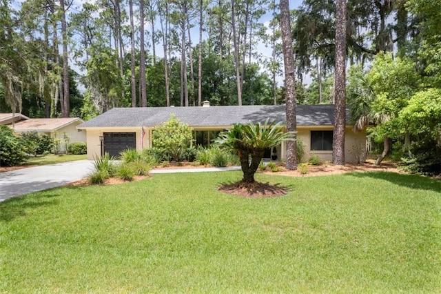 552 Old Plantation Rd, Jekyll Island, GA 31527 - single story home featuring driveway, an attached garage, a front yard, and view of wooded area