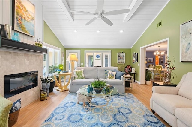 552 Old Plantation Rd, Jekyll Island, GA 31527 - living area featuring wood finished floors, a tiled fireplace, ceiling fan, a chandelier, and high vaulted ceiling