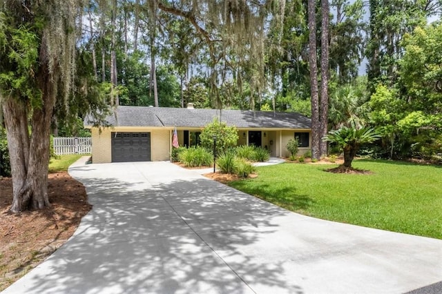552 Old Plantation Rd, Jekyll Island, GA 31527 - ranch-style home with concrete driveway, a garage, view of wooded area, and a chimney