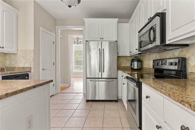 108 Northwind Dr, Brunswick, GA 31523 - kitchen with light tile patterned floors, white cabinets, decorative backsplash, and stainless steel appliances