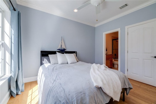 bedroom with crown molding, ensuite bathroom, light hardwood / wood-style floors, and multiple windows