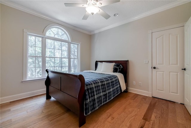 bedroom with multiple windows, crown molding, and light hardwood / wood-style floors