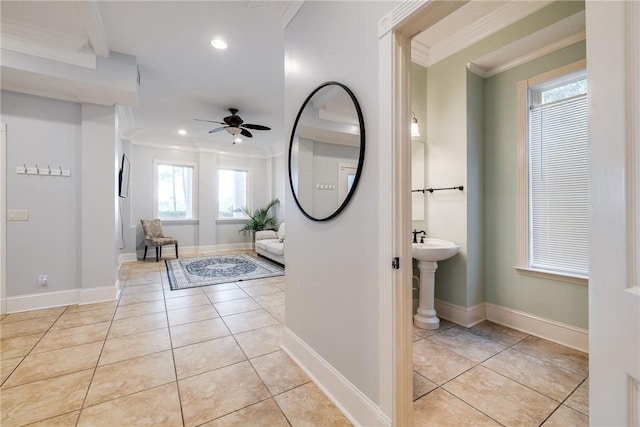 tiled entrance foyer featuring crown molding and ceiling fan