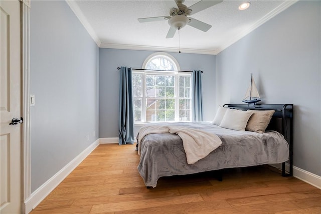 bedroom featuring crown molding, a textured ceiling, ceiling fan, and light wood-type flooring