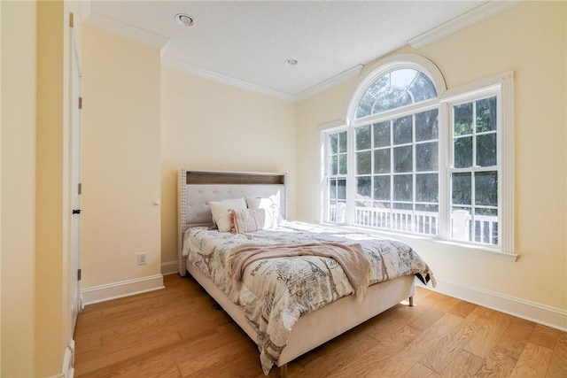 bedroom featuring crown molding and light hardwood / wood-style flooring