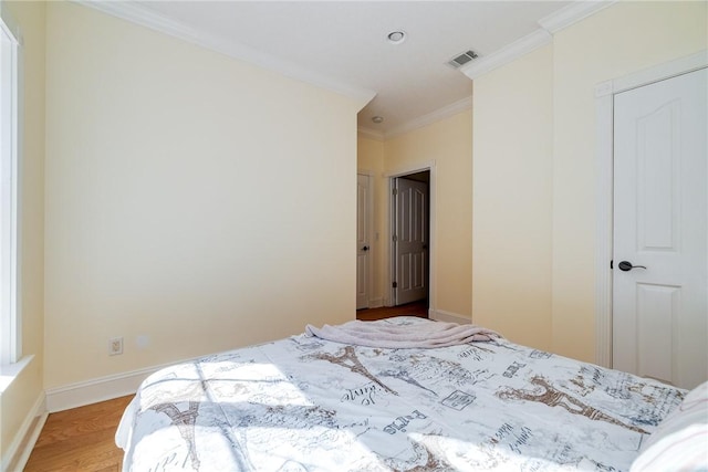 bedroom with wood-type flooring and ornamental molding