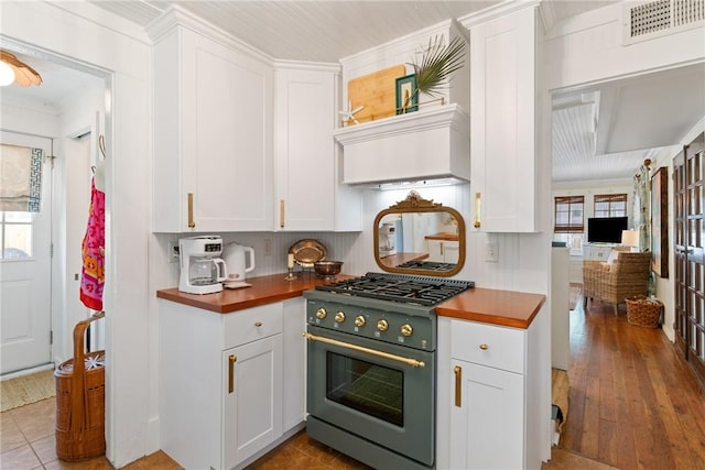 405 Everett St, Saint Simons Island, GA 31522 - kitchen featuring high end range, white cabinets, butcher block counters, ornamental molding, and wood finished floors