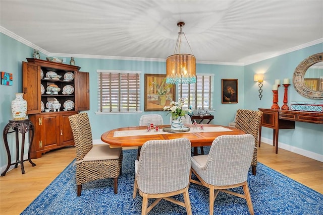 246 Alabama St, Saint Simons Island, GA 31522 - dining room featuring a chandelier, light wood-type flooring, ornamental molding, and baseboards