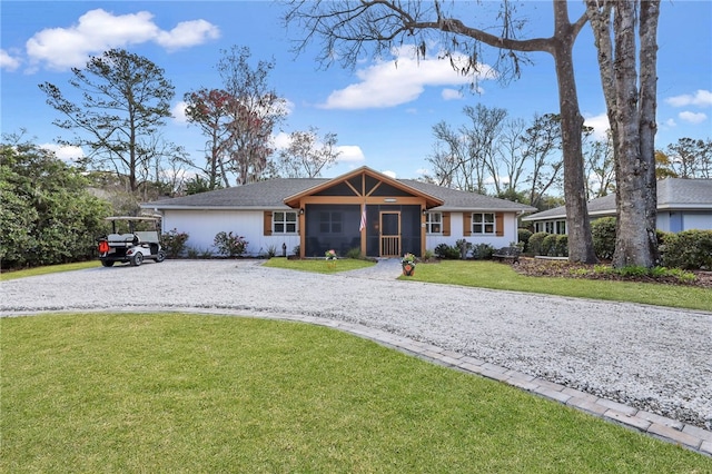246 Alabama St, Saint Simons Island, GA 31522 - single story home featuring gravel driveway, a sunroom, and a front lawn
