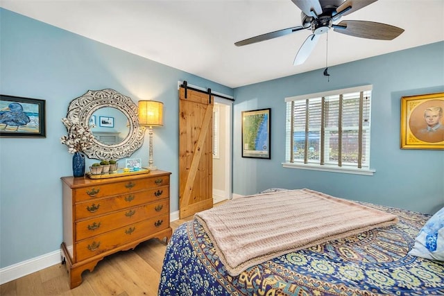 246 Alabama St, Saint Simons Island, GA 31522 - bedroom with wood finished floors, a barn door, baseboards, and ceiling fan