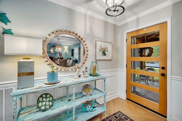 246 Alabama St, Saint Simons Island, GA 31522 - entrance foyer with a chandelier, crown molding, a wainscoted wall, and wood finished floors