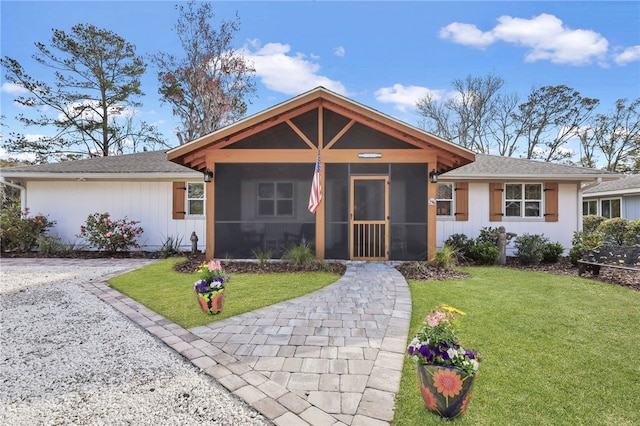 246 Alabama St, Saint Simons Island, GA 31522 - ranch-style house featuring a sunroom, a front lawn, and a shingled roof
