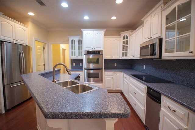 kitchen featuring sink, tasteful backsplash, white cabinetry, a center island with sink, and stainless steel appliances