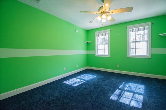 interior space featuring dark colored carpet, vaulted ceiling, ceiling fan, and a textured ceiling