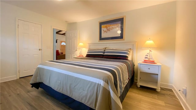 bedroom with baseboards and wood finished floors