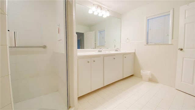 bathroom featuring double vanity, a sink, and a stall shower