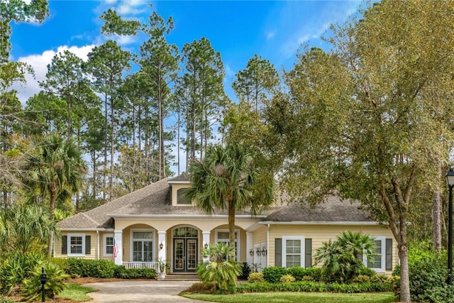 view of front of property featuring roof with shingles and covered porch