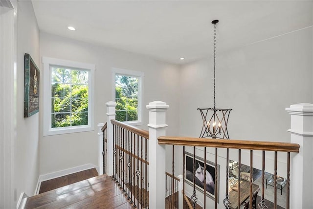 107 Reynoso Ave, Saint Simons Island, GA 31522 - hallway featuring an upstairs landing, wood finished floors, a chandelier, baseboards, and recessed lighting