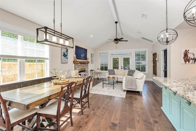 107 Reynoso Ave, Saint Simons Island, GA 31522 - dining room with dark wood-style floors, a ceiling fan, a brick fireplace, french doors, and a chandelier