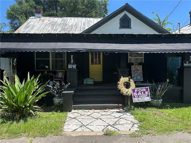 1308 Martin Luther King Jr Blvd, Brunswick, GA 31520 - view of front of property with covered porch, a chimney, a metal roof, and a standing seam roof