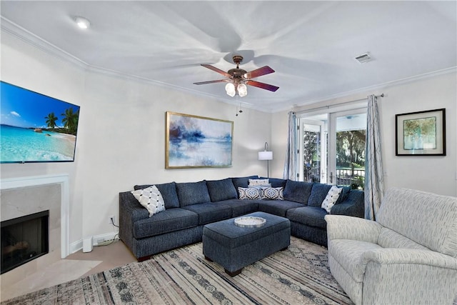 living room with crown molding, a high end fireplace, and ceiling fan