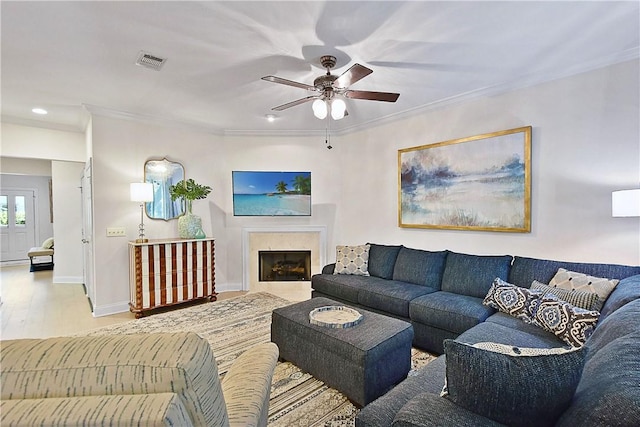 living room with ceiling fan, ornamental molding, and light wood-type flooring