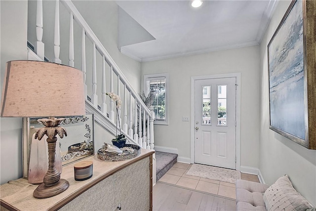 tiled foyer entrance with crown molding