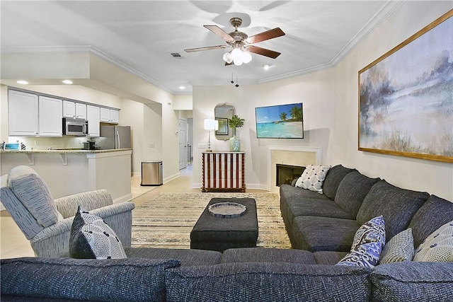 living room with light tile patterned floors, ceiling fan, and ornamental molding