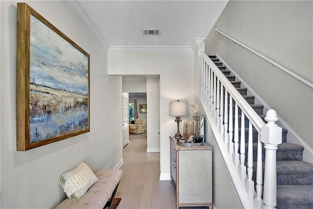 stairway featuring wood-type flooring and ornamental molding