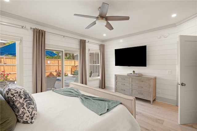 bedroom featuring ceiling fan, access to outside, wood walls, and light wood-style floors